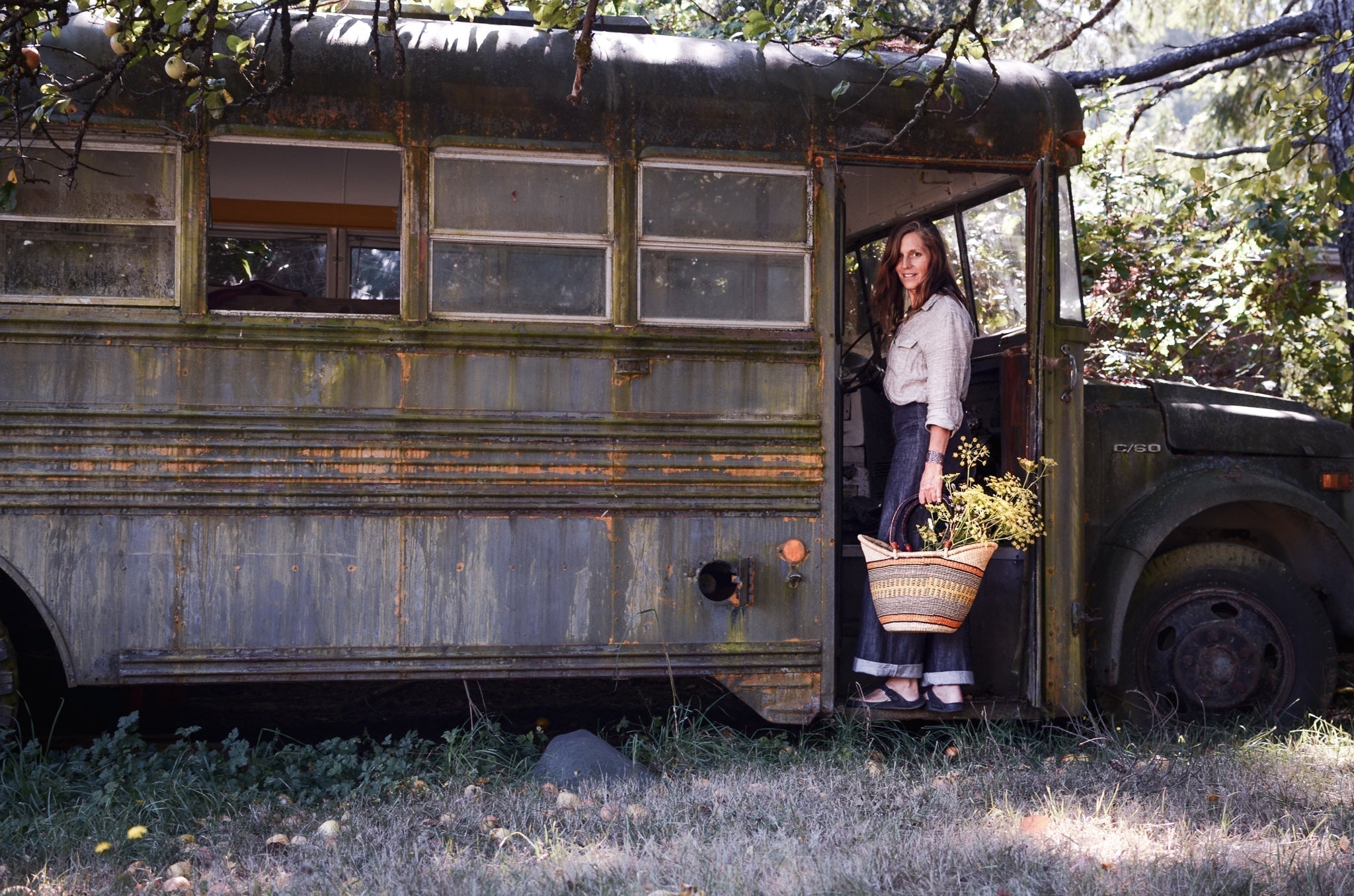 a woman standing on an aging bus with a basket of flowers in her hand