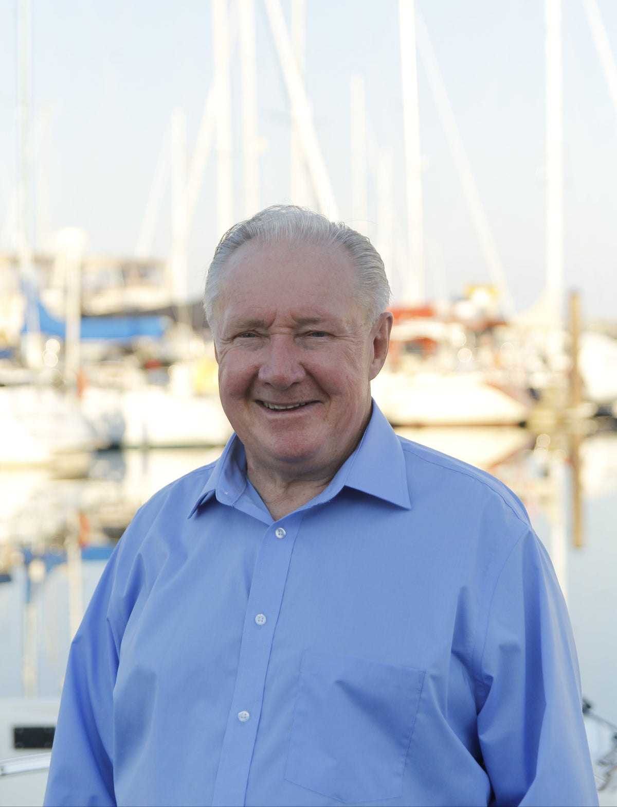 Man in a blue shirt standing outdoors with blurred background