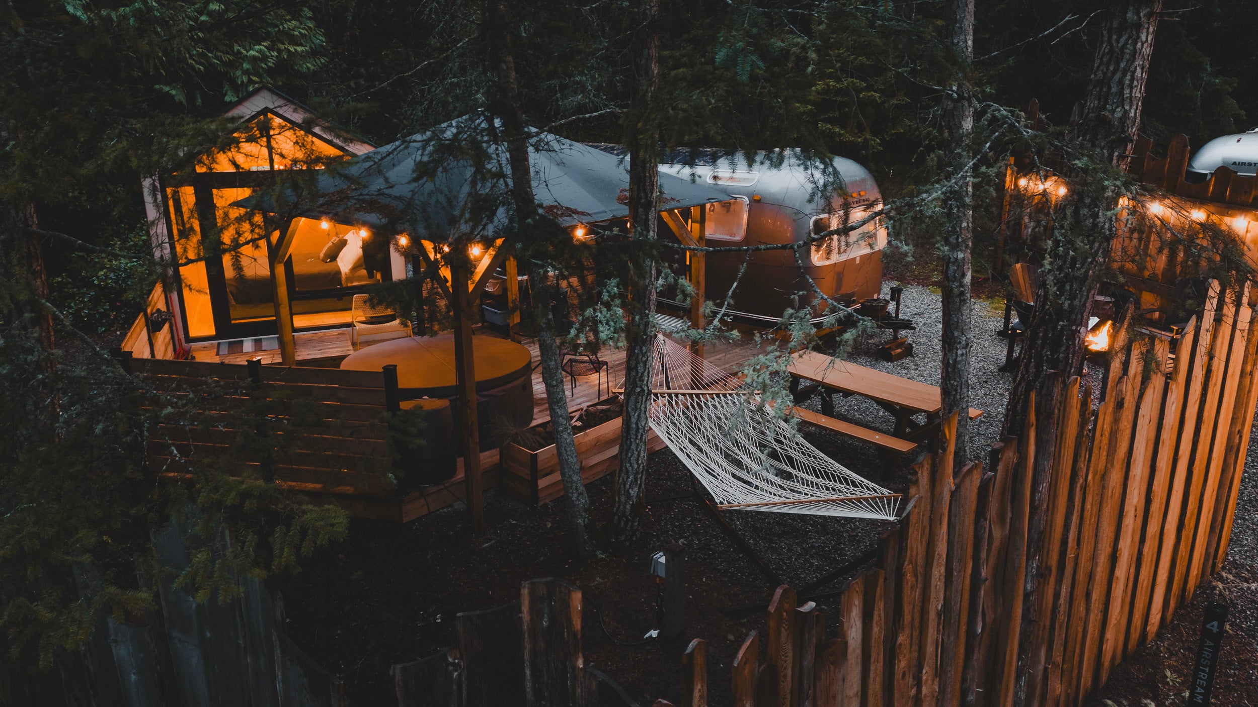 WOODS on Pender for FOLKLIFE CommunityFOLK - an airstream and bunkie cabin set up in the woods with a hammock