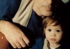 Man and child sitting together, with a close-up of their faces.